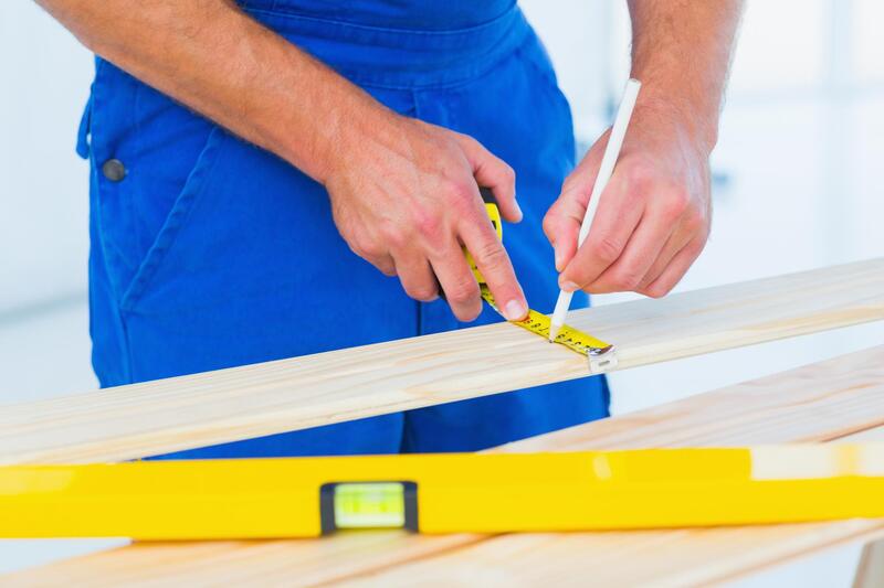 carpenter measuring wood material